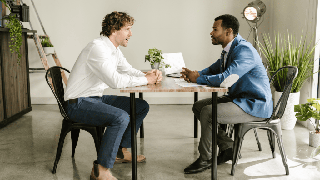 two professional men having a conversation at a table