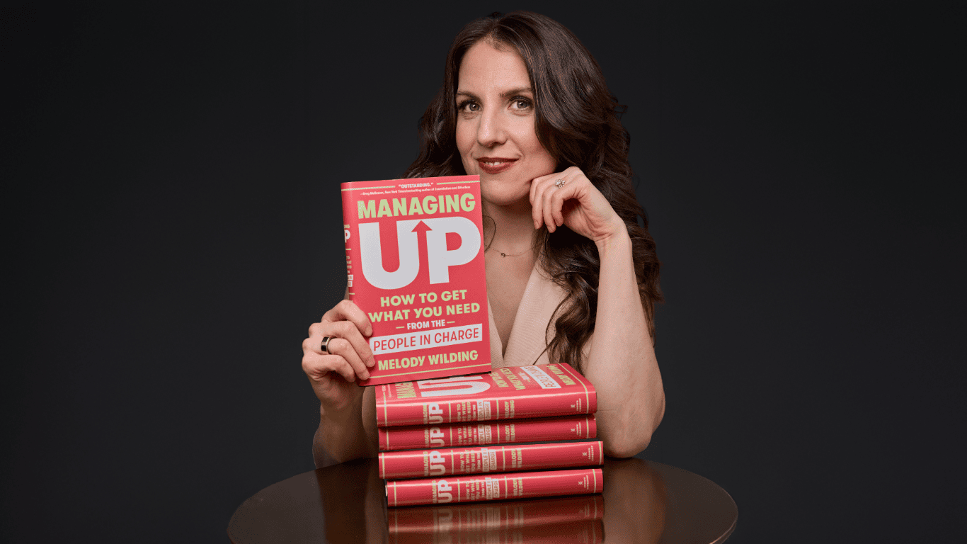 Melody holding a copy of her new book Managing UP